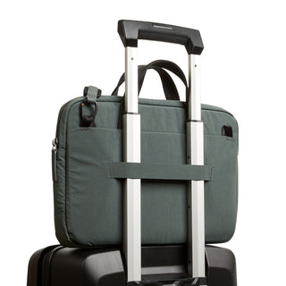 Bellroy Tokyo Laptop Bag 14" in green attaches securely to suitcase handle for easy travel.