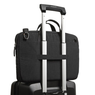 Bellroy Tokyo Laptop Bag 16" in black fabric secured on silver suitcase handle from rear view