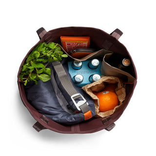 Bellroy Market Tote open top view filled with groceries including an orange and bottled drinks