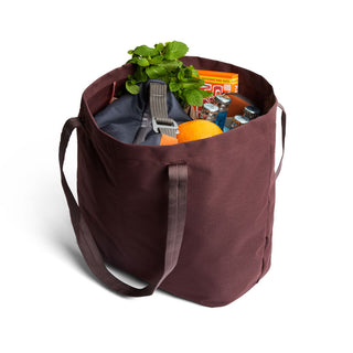 Bellroy Market Tote in brown recycled nylon filled with groceries including herbs and canned goods