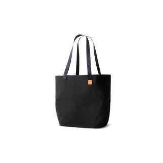 Black Bellroy Market Tote with long navy handles and small orange logo tag