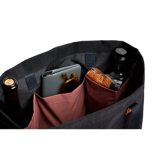 Bellroy Market Tote showing organized interior pockets holding bottles and personal items in black recycled nylon