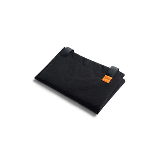 Bellroy Market Tote folded flat showing black recycled nylon fabric with orange brand tag detail
