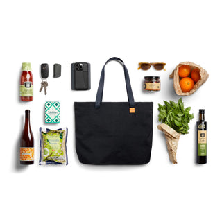 Bellroy Market Tote in black recycled nylon with long handles, surrounded by groceries and essentials