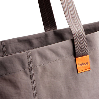 Bellroy Market Tote in grey recycled nylon with contrasting orange logo tag and sturdy handles close-up