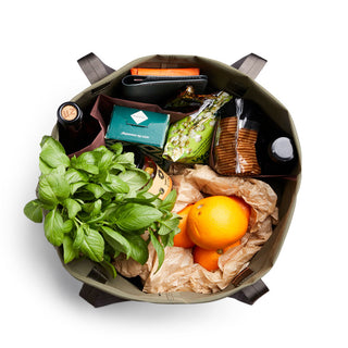 Bellroy Market Tote filled with groceries including fresh greens, oranges, packaged goods in recycled nylon bag