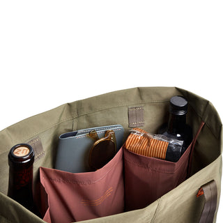 Bellroy Market Tote interior with multiple compartments holding bottles, wallet, and packaged snack visible