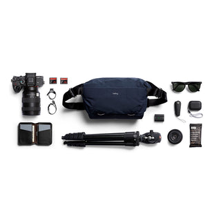 Bellroy Venture Sling 10L - Camera Edition in navy blue with camera gear and accessories laid out nearby