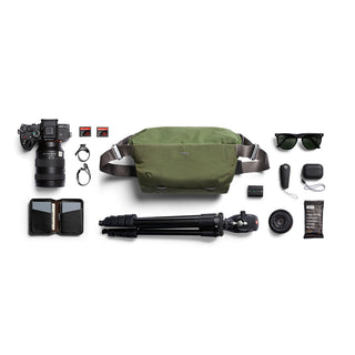 Bellroy Venture Sling 10L - Camera Edition in olive green with compact camera gear and accessories displayed flat