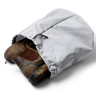 Bellroy Venture Duffel 55L light gray waterproof shoe bag with drawstring closure and rugged boots inside