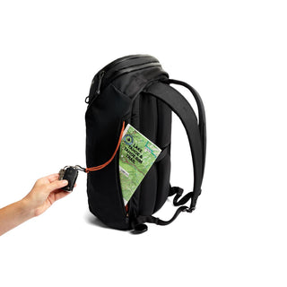 Bellroy Venture Travel Pack 26L in black with side pocket holding a map and a hand with keys