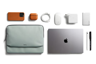 Bellroy Laptop Caddy 16" in soft green fabric alongside tech accessories and a laptop on white background