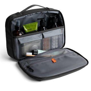 Bellroy Hanging Toiletry Kit Plus open with organized travel bottles and compartments in dark grey fabric