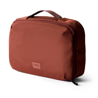 Bellroy Hanging Toiletry Kit Plus in rust red with durable recycled fabric and sturdy top handle design