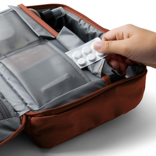 Bellroy Hanging Toiletry Kit Plus in brown showing organized compartments with mesh pockets and medication storage