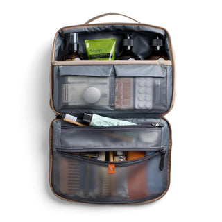 Bellroy Hanging Toiletry Kit Plus in tan with multiple compartments holding travel-sized bottles and accessories