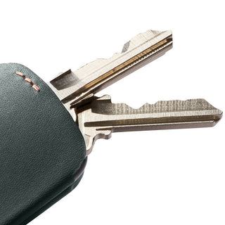 Bellroy Key Cover Third Edition in dark green leather holding two silver keys with visible texture