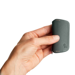 Bellroy Key Cover Third Edition in dark leather held in hand showing slim, smooth texture and stitching details