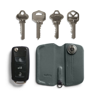 Bellroy Key Cover Third Edition in dark green leather with lock mechanism and four keys alongside a car key fob