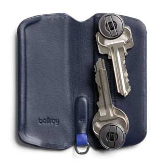 Bellroy Key Cover Plus Third Edition in navy leather holding two metallic keys with secure button fasteners