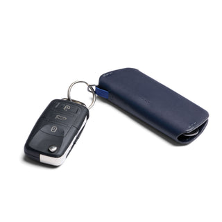 Bellroy Key Cover Plus Third Edition in navy leather attached to a black car key fob on white background