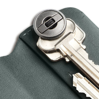 Bellroy Key Cover Plus Third Edition in dark green leather holding metal keys with stitched edges
