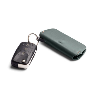 Bellroy Key Cover Plus Third Edition in green leather attached to a car key on white background