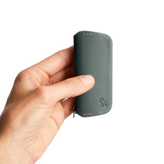Hand holding Bellroy Key Cover Plus Third Edition in dark gray leather with embossed owl logo