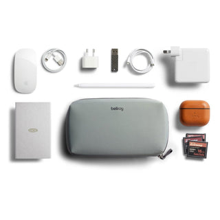 Bellroy Tech Kit in gray fabric pouch with tech accessories neatly arranged on white background