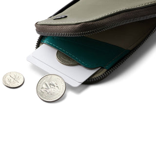 Bellroy Card Pocket showing open zipper with cards and coins inside against white background