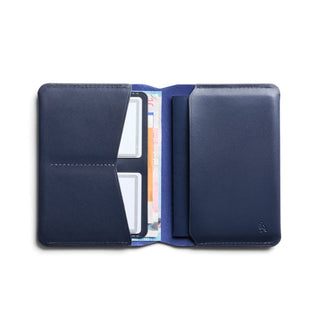 Bellroy Passport Cover in navy leather opened to show card slots and currency compartment inside