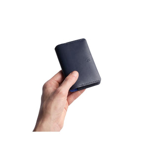 Bellroy Under Cover navy blue leather card holder held in hand showing compact size and smooth texture