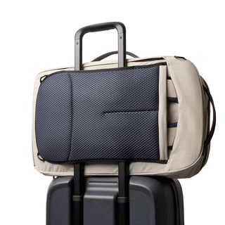 Bellroy Lite Travel Pack 38L beige backpack with padded back panel attached to suitcase handle
