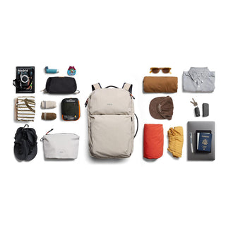 Bellroy Lite Travel Pack 38L in light beige with travel essentials neatly arranged around it