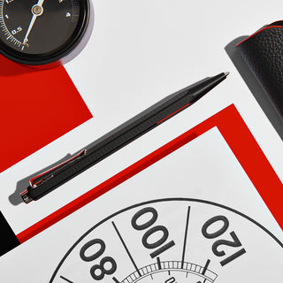 Caran d'Ache Matt Ecridor Racing Ballpoint Pen with matte black finish and red lacquer accents displayed on white background
