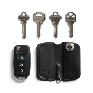 Bellroy Key Cover Third Edition in black leather with keys and car remote beside it on white background