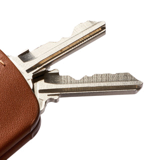 Bellroy Key Cover Third Edition in brown leather protecting two metal keys with textured grain visible