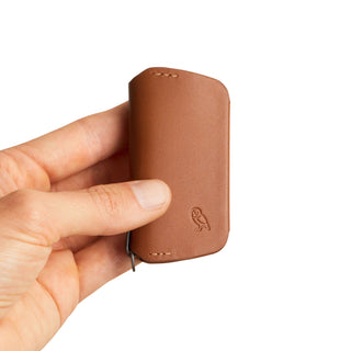 Bellroy Key Cover Third Edition in brown leather held in hand showing embossed owl logo and stitching details