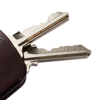 Bellroy Key Cover Third Edition in dark brown leather holding two silver keys close-up angle