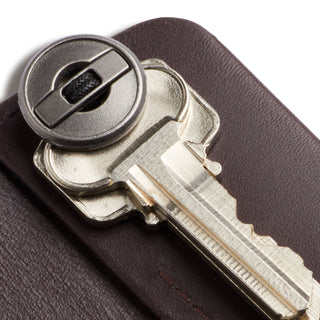 Bellroy Key Cover Third Edition in dark brown leather holding a single metal key securely