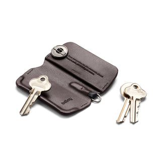 Bellroy Key Cover Third Edition in dark brown leather holding two keys with an additional two keys nearby