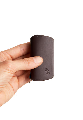 Bellroy Key Cover Third Edition in dark leather held showing embossed owl logo and smooth texture