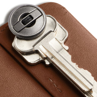 Bellroy Key Cover Third Edition showcasing smooth tan leather texture with a silver key inserted close-up view