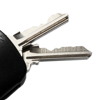 Bellroy Key Cover Plus Third Edition showing textured black leather with attached metal keys close-up