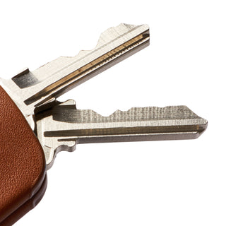 Bellroy Key Cover Plus Third Edition with textured brown leather holding two silver keys close-up view