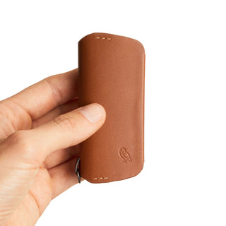 Bellroy Key Cover Plus Third Edition in smooth tan leather held in hand showing embossed owl logo