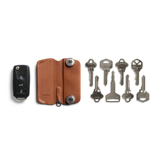 Bellroy Key Cover Plus Third Edition in brown leather with keys and car remote arranged nearby on white background