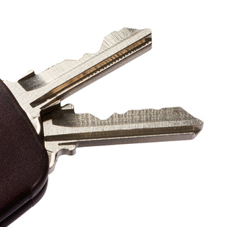 Bellroy Key Cover Plus Third Edition dark brown leather key organizer holding two silver keys close-up