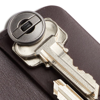 Bellroy Key Cover Plus Third Edition in dark brown leather protecting silver keys with metal button closure