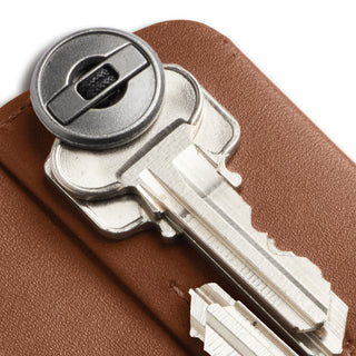 Bellroy Key Cover Plus Third Edition in brown leather with close-up on metal key and smooth texture